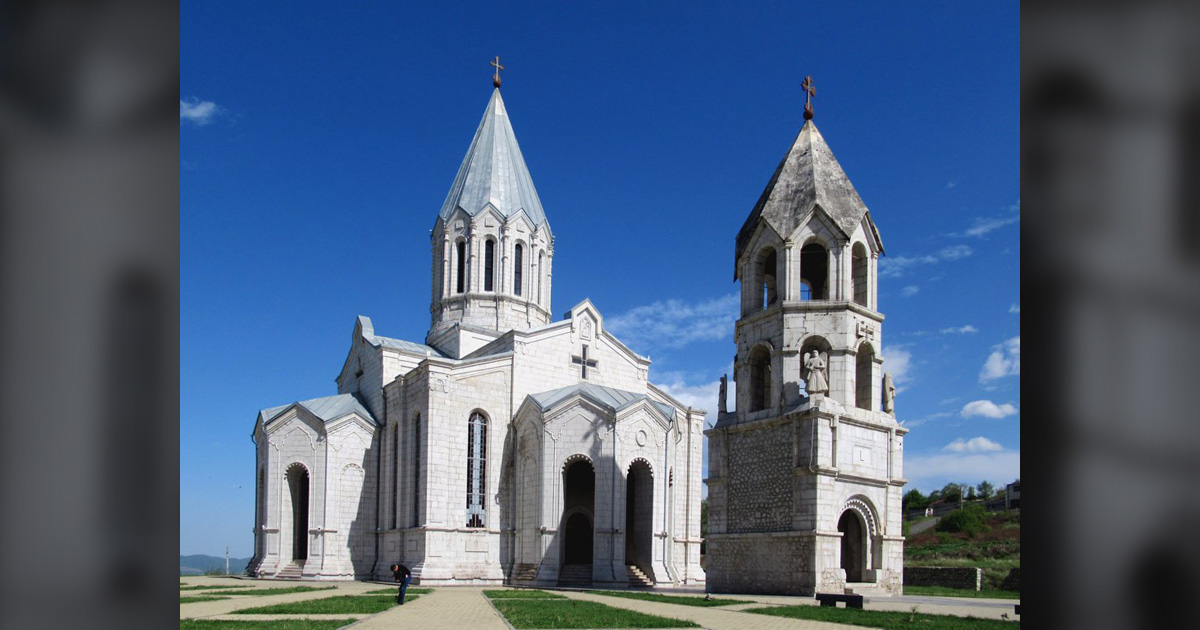 A light grey cathedral is highlighted against a blue sky.