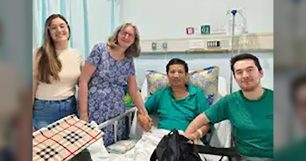 John Cao smiles as his wife, daughter, and son visit him in the hospital. John Cao smiles as his wife, daughter, and son visit him in the hospital.
