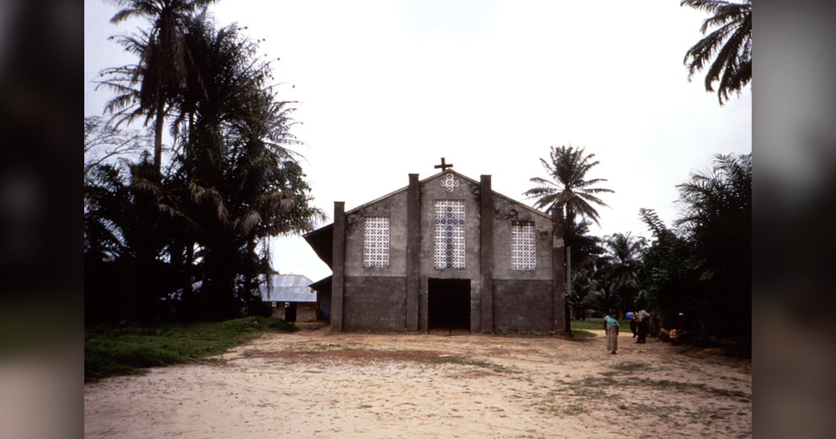A church building is surrounded by palm trees.