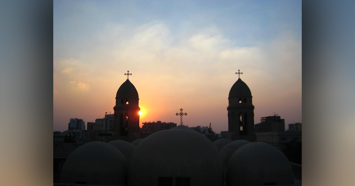 A church is silhouetted against a darkening sky.