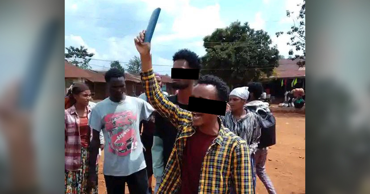 People are gathered as two men preach in the open air.