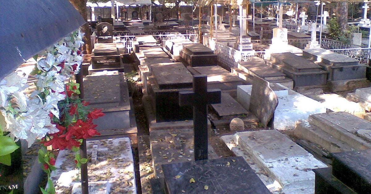 A cemetery shows graves arranged closely together.