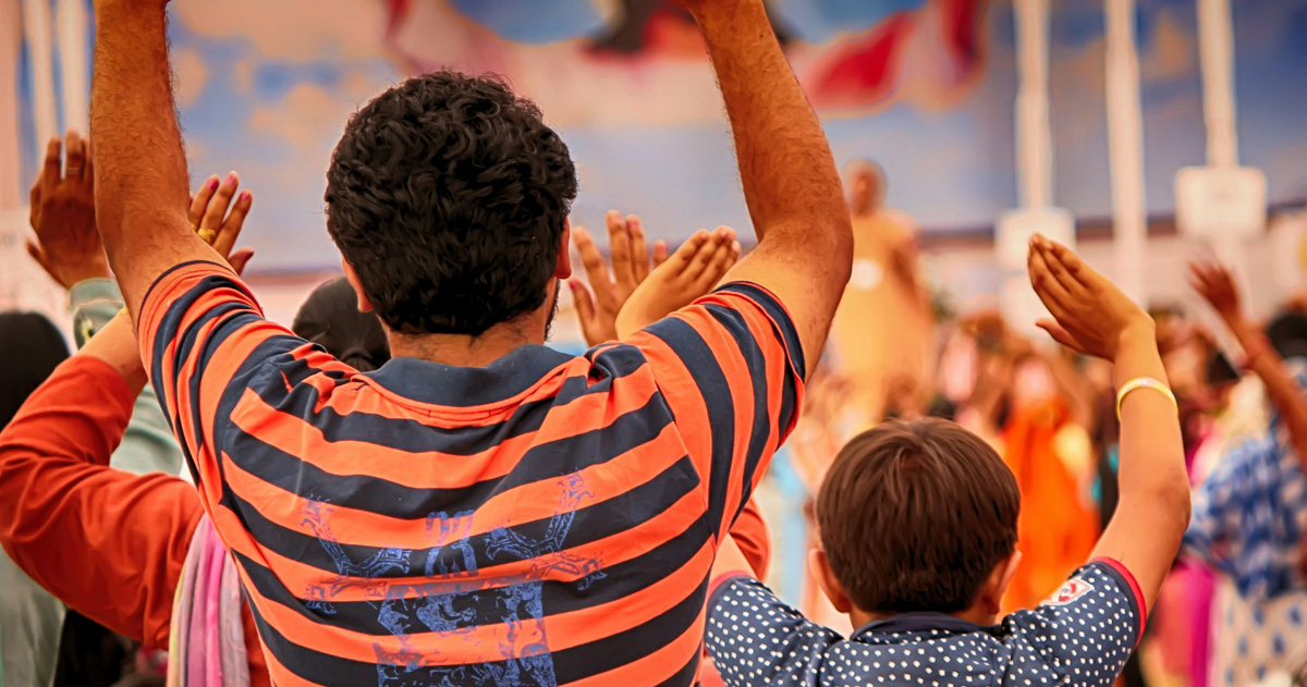 Worshippers have their hands raised in worship.