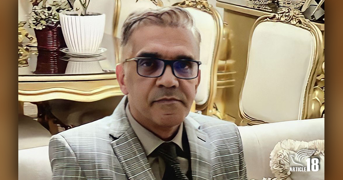 Pastor Nasser Navard Gol-Tapeh is in a suit and seated on a sofa.