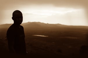 A boy sillhouetted against a sunset - Photo: Unsplash / Steve Wafula