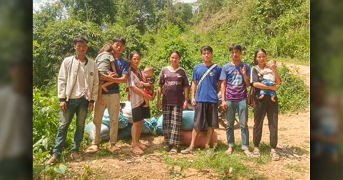 Seven adults and three small children are at the side of a road.