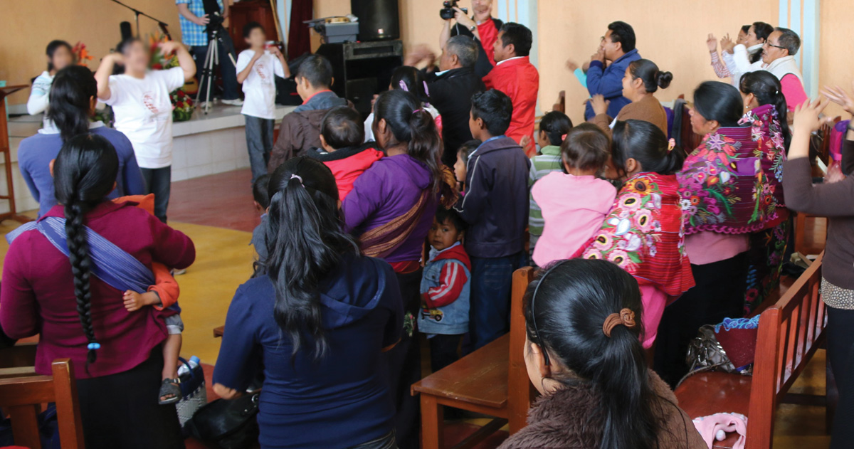 A congregation in Mexico is standing together.