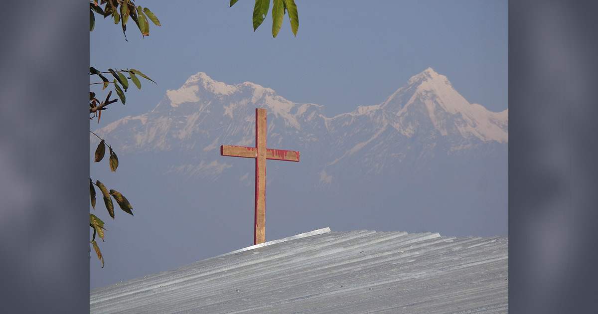 A cross sits atop a church in the Himalayas