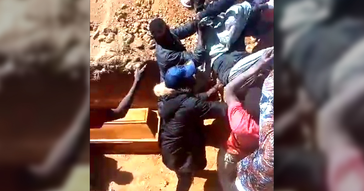 Several people are helping to lay a loved one to rest. Several people are helping to lay a loved one to rest.