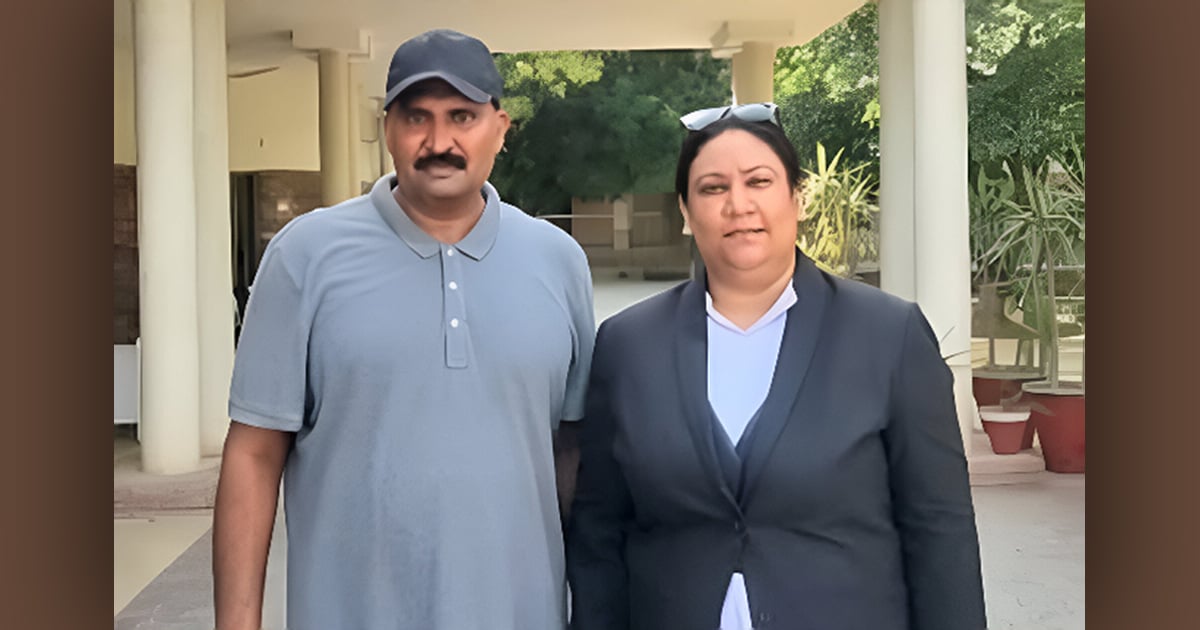 Haroon is standing with his lawyer in a portico.