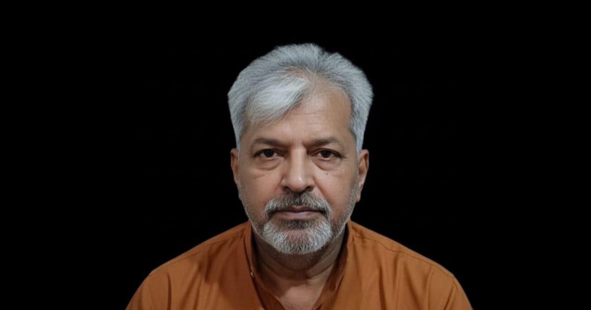 Brother Zafar has an orange shirt on and is looking directly at the viewer.