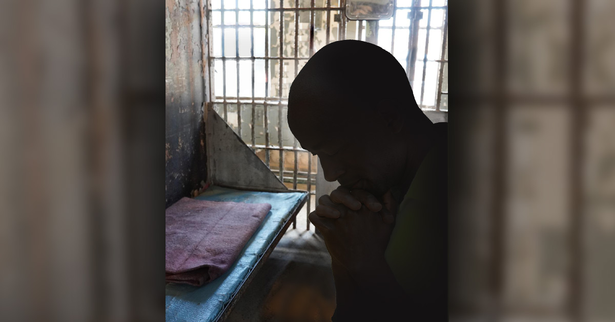 Man praying in prison Man praying in prison