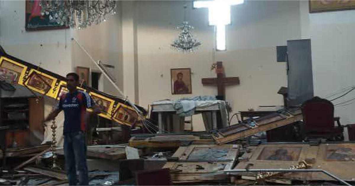 A man is standing amidst debris and broken-down icons in the aftermath of the bombing. A man is standing amidst debris and broken-down icons in the aftermath of the bombing.