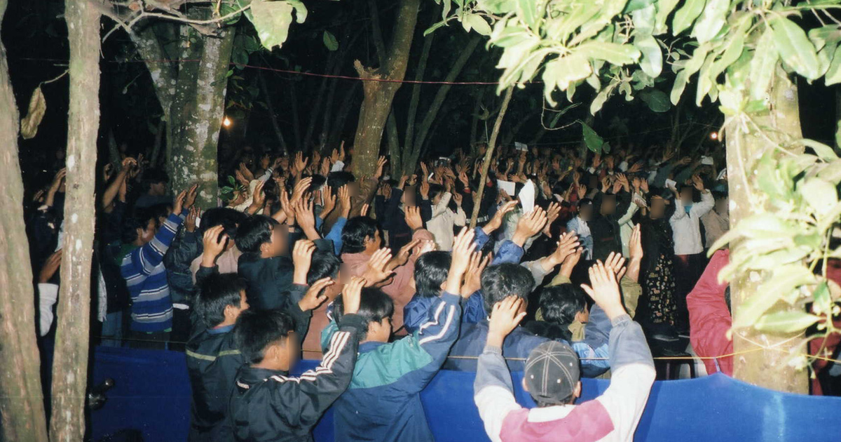 A group of believers is gathered outdoors. Most people have their hands raised. A group of believers is gathered outdoors. Most people have their hands raised.