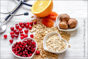Fruit, grains, and nuts are arranged on a table and in heart-shaped bowls. A stethoscope sits beside the food. Fruit, grains, and nuts are arranged on a table and in heart-shaped bowls. A stethoscope sits beside the food.