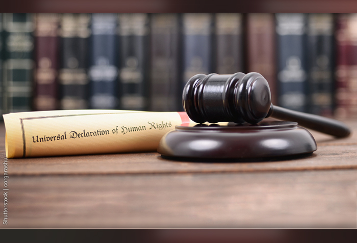 A rolled up document with the title, "Universal Declaration of Human Rights" sitting beside a gavel.
