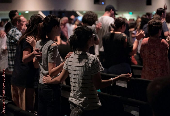 A church congregation is standing in worship. A church congregation is standing in worship.